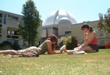 Students reading on the grass outside Murray Edwards College