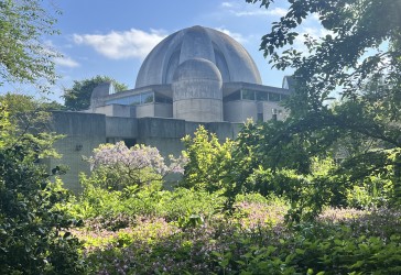 Dome of Murray Edwards College with sunny gardens in foreground