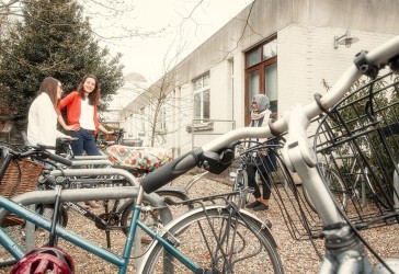 Photo of students outside near the bicycle racks