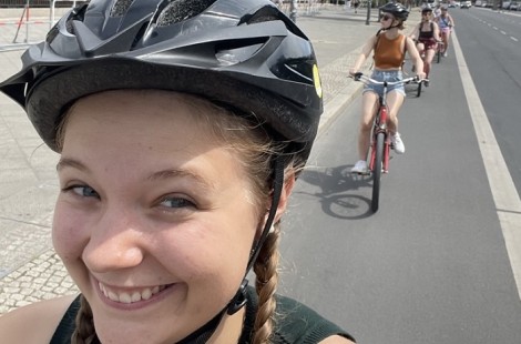 Sophie is smiling into the camera while on a bike tour.