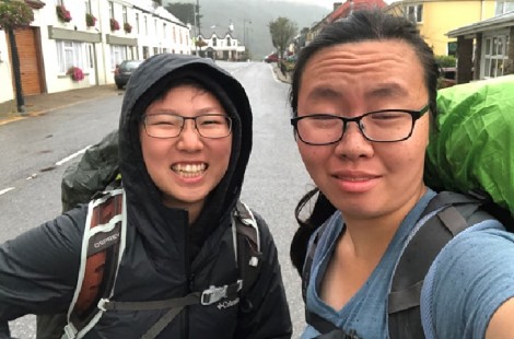 You Qi and friend hiking along a street
